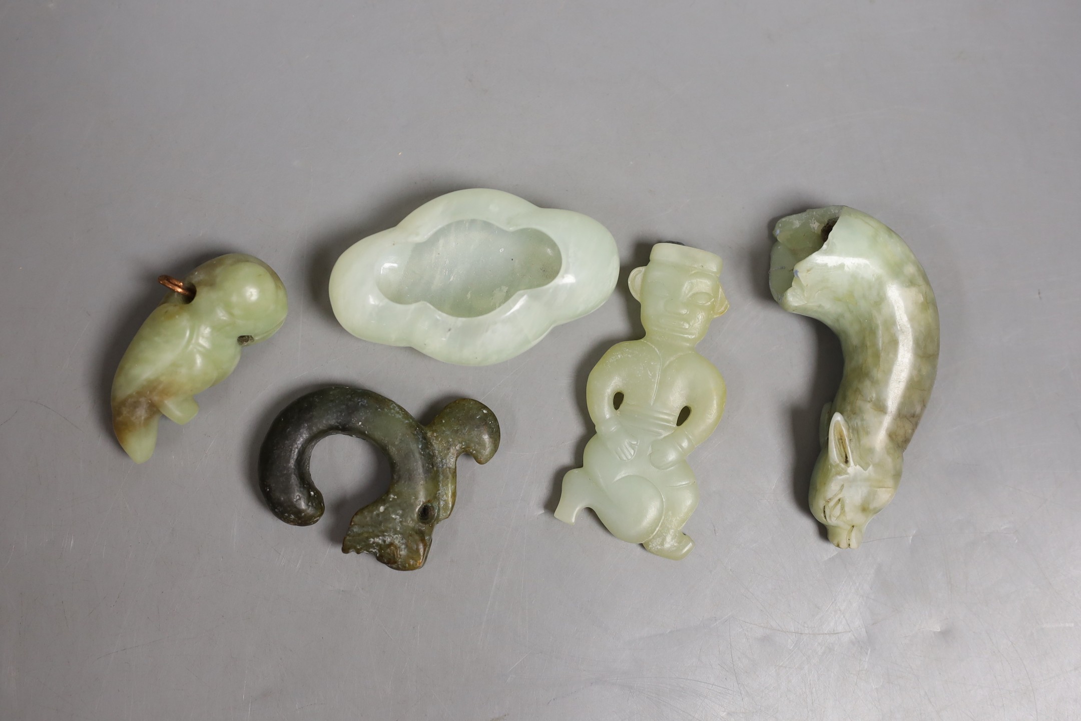 Four Chinese jade or hardstone carvings and a brushwasher, largest 9.2cm